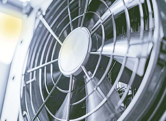 Close-up de um ventilador com grade de prote&ccedil;&atilde;o, utilizado para a circula&ccedil;&atilde;o de ar e dissipa&ccedil;&atilde;o de calor.